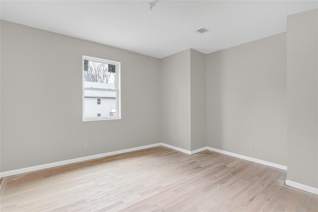 empty room featuring visible vents, baseboards, and light wood-style floors