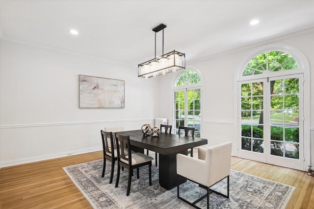 dining room with ornamental molding, light wood-style floors, recessed lighting, radiator heating unit, and baseboards