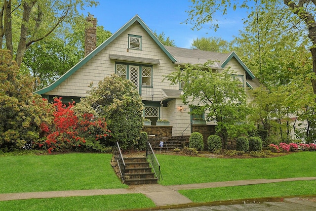 english style home with a chimney and a front yard