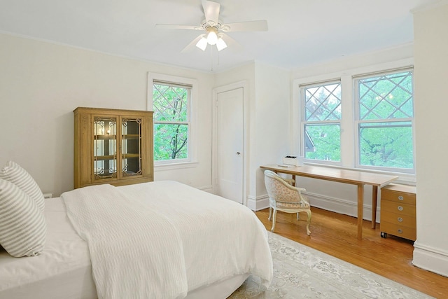 bedroom featuring light wood-style floors, ceiling fan, and baseboards