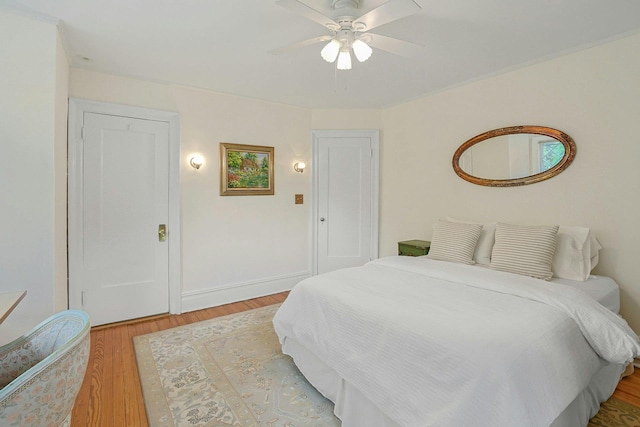 bedroom featuring light wood-style floors, a ceiling fan, and baseboards