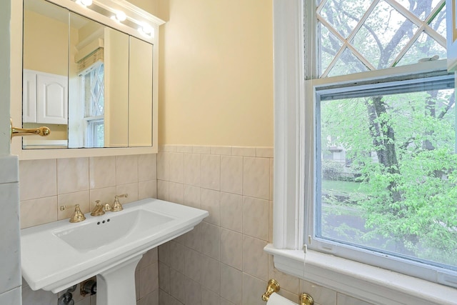 bathroom featuring tile walls, plenty of natural light, and a wainscoted wall