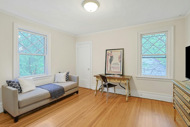 sitting room with plenty of natural light, light wood finished floors, ornamental molding, and baseboards