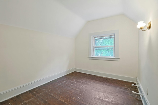bonus room featuring dark wood-style floors, lofted ceiling, and baseboards