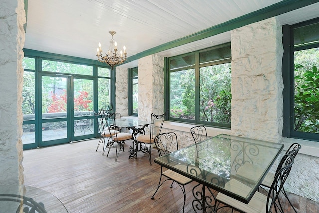 sunroom featuring a chandelier and french doors