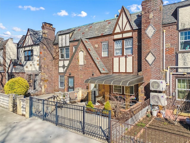 21-25 146th St, Whitestone, NY 11357 - tudor-style house featuring brick siding, a high end roof, fence, and ac unit