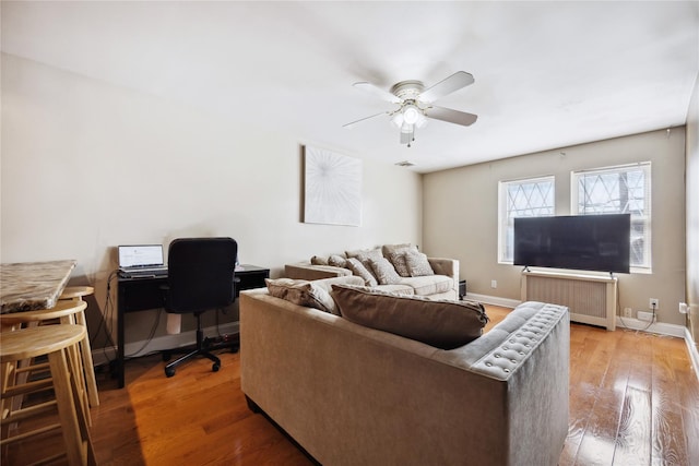 21-25 146th St, Whitestone, NY 11357 - living area with light wood-style floors, radiator heating unit, baseboards, and ceiling fan