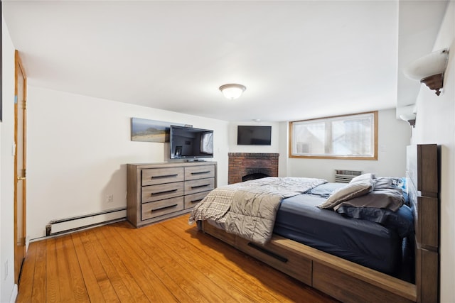 21-25 146th St, Whitestone, NY 11357 - bedroom featuring baseboard heating, a brick fireplace, and light wood-style floors