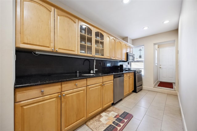 21-25 146th St, Whitestone, NY 11357 - kitchen featuring dark stone counters, a sink, glass insert cabinets, stainless steel appliances, and baseboards