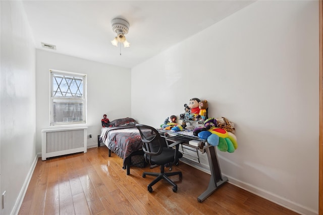 21-25 146th St, Whitestone, NY 11357 - bedroom featuring radiator, wood-type flooring, visible vents, and baseboards