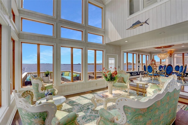 505 E Dr, Copiague, NY 11726 - living room with a towering ceiling, a water view, wood finished floors, and wooden walls