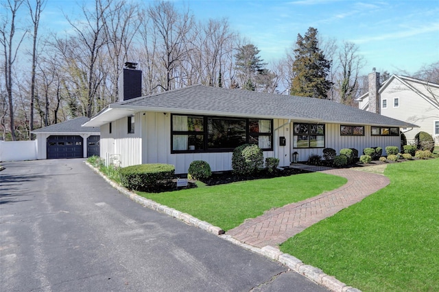 11 Cannon Ct, Huntington, NY 11743 - view of front of house with a front yard, roof with shingles, board and batten siding, and a chimney