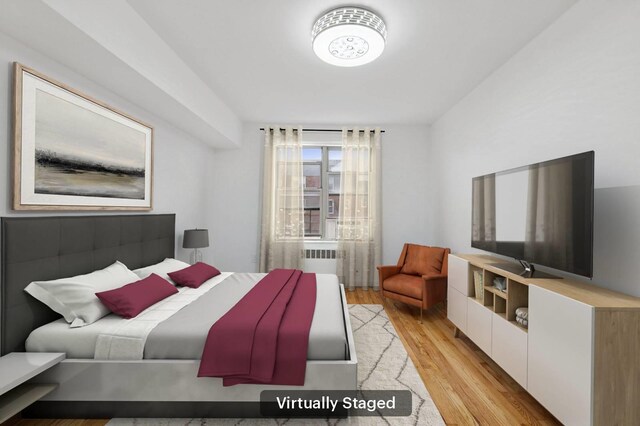 bedroom featuring light wood-style flooring and radiator heating unit
