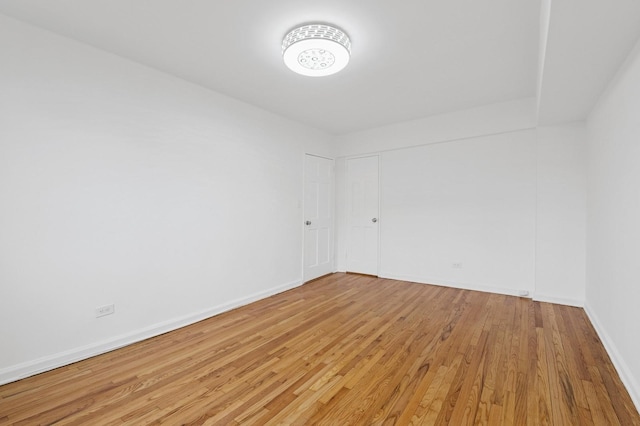 empty room with light wood-style flooring and baseboards