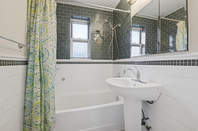 bathroom with shower / bath combo, a wealth of natural light, and tile walls