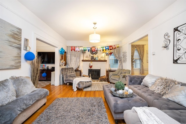 living area featuring a brick fireplace and wood finished floors