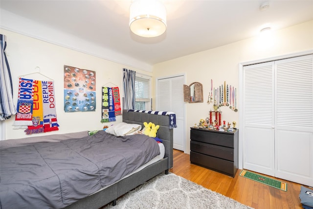 bedroom with two closets and light wood-style floors
