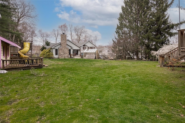 view of yard with a deck and a playground