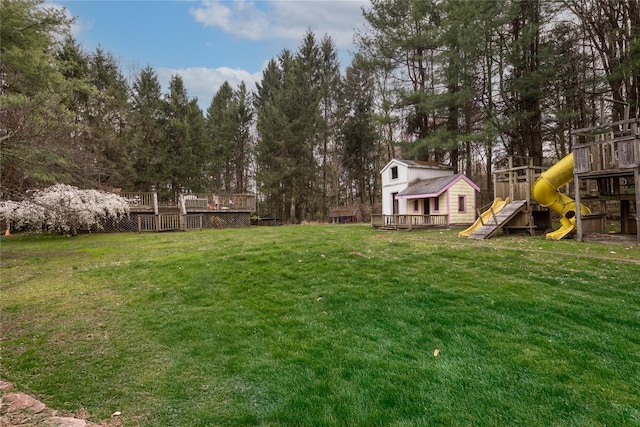 view of yard with a wooden deck and a playground
