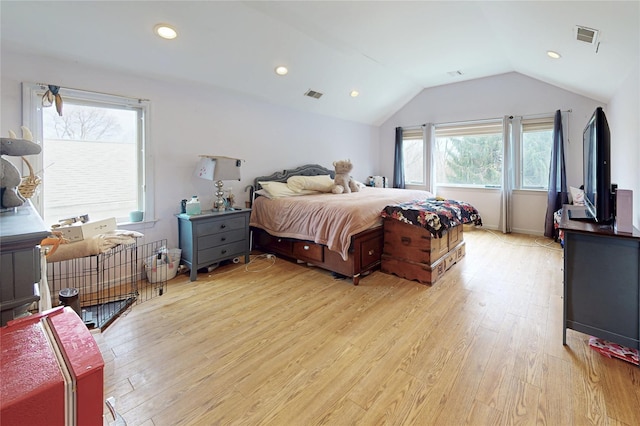 bedroom with lofted ceiling, visible vents, and light wood-type flooring