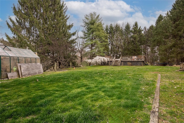 view of yard featuring an exterior structure, an outbuilding, and a deck