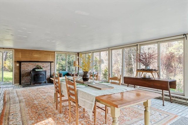 sunroom featuring a wood stove and a healthy amount of sunlight