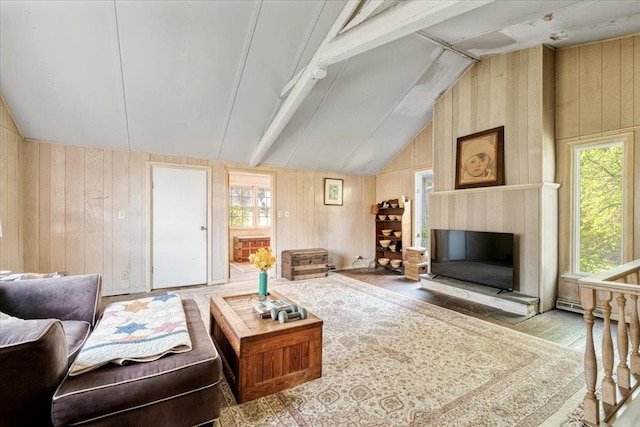 living room with wood walls, wood finished floors, a fireplace with raised hearth, and vaulted ceiling with beams