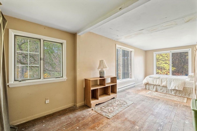 bedroom with wood-type flooring, baseboards, and a baseboard radiator