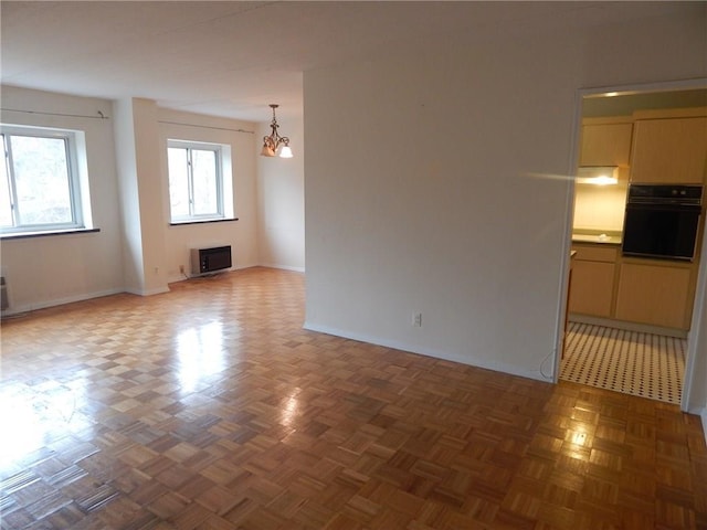 412 Benedict Ave Unit 5J, Tarrytown, NY 10591 - unfurnished living room with a chandelier and baseboards