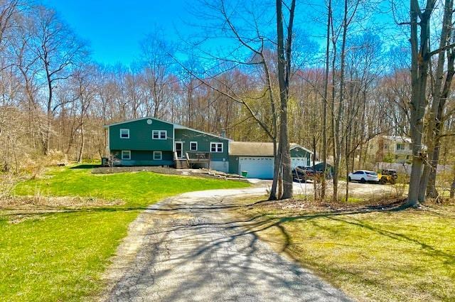 view of front of home featuring driveway, a garage, and a front lawn