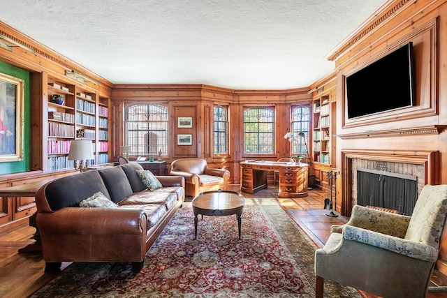 31 Fort Hill Dr, Lloyd Harbor, NY 11743 - living room featuring wooden walls, built in features, a fireplace with flush hearth, and a textured ceiling