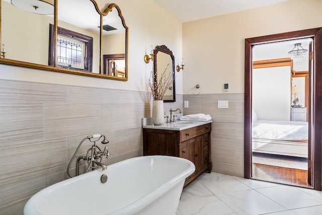 31 Fort Hill Dr, Lloyd Harbor, NY 11743 - full bathroom featuring a soaking tub, ensuite bathroom, vanity, marble finish floor, and tile walls