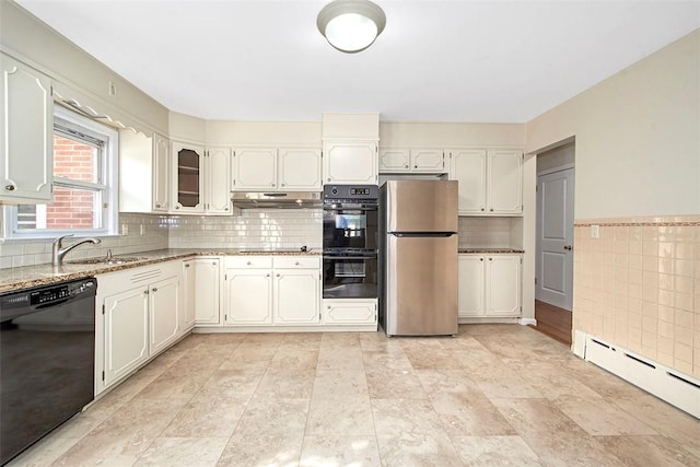 kitchen featuring a sink, a baseboard heating unit, black appliances, under cabinet range hood, and light stone countertops