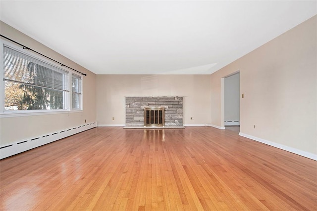 unfurnished living room featuring a baseboard radiator, baseboards, light wood-style floors, and a fireplace