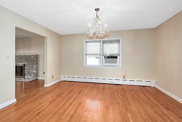unfurnished dining area with a baseboard heating unit, a notable chandelier, light wood-style floors, and cooling unit