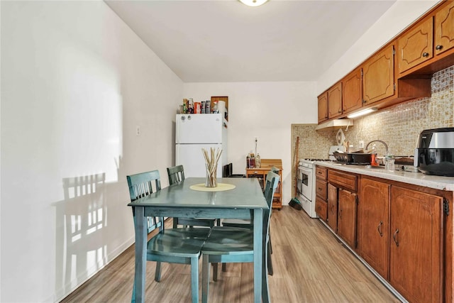 3145 37th St, Astoria, NY 11103 - kitchen featuring white appliances, brown cabinetry, tasteful backsplash, light countertops, and light wood finished floors
