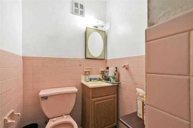 3145 37th St, Astoria, NY 11103 - bathroom with vanity, visible vents, a wainscoted wall, toilet, and tile walls