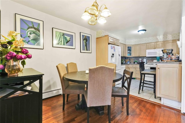 3145 37th St, Astoria, NY 11103 - dining room with hardwood / wood-style floors, baseboard heating, and an inviting chandelier