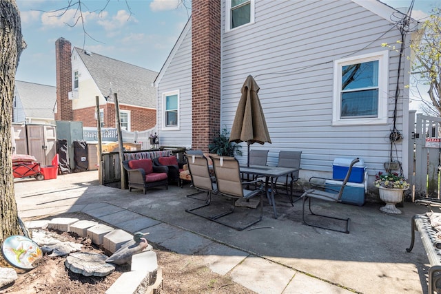 view of patio with outdoor dining space and fence