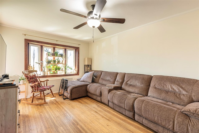 living area with light wood-style flooring, crown molding, and ceiling fan
