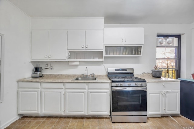 kitchen featuring white cabinetry, stainless steel range with gas stovetop, a sink, and open shelves