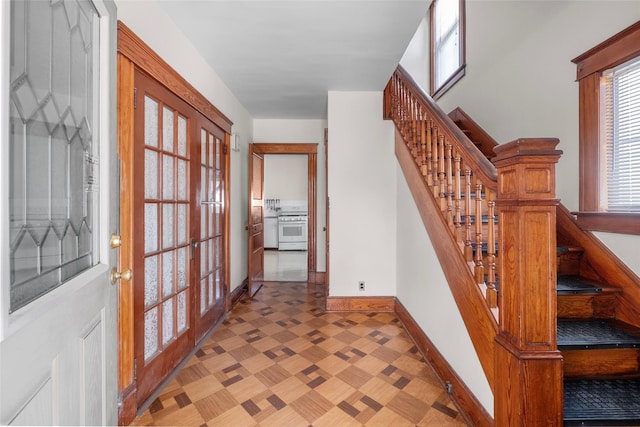 entryway with french doors, baseboards, and stairs