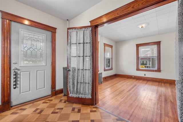 foyer featuring baseboards, light wood-type flooring, and radiator