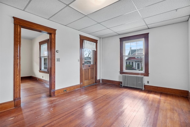 foyer featuring a paneled ceiling, radiator heating unit, wood-type flooring, and baseboards