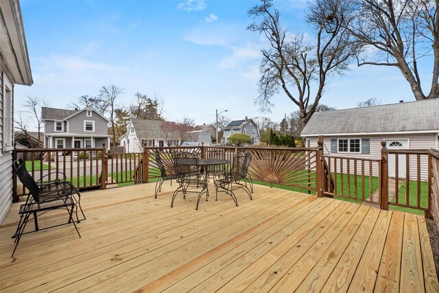 wooden terrace with a residential view and outdoor dining area