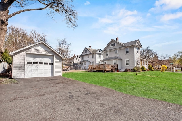 view of side of home featuring a garage, a yard, a deck, and an outdoor structure