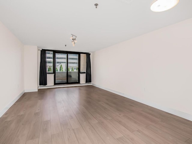 25 Rockledge Ave Unit 117, White Plains, NY 10601 - spare room featuring baseboards, wood finished floors, and a wall of windows
