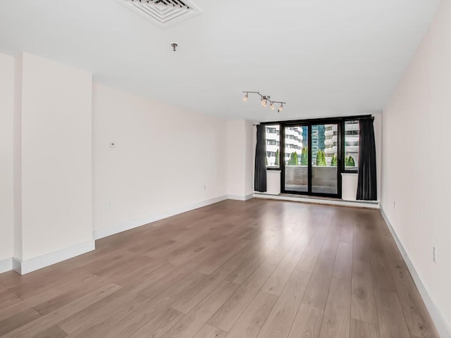 25 Rockledge Ave Unit 117, White Plains, NY 10601 - spare room with rail lighting, visible vents, baseboards, and light wood-style flooring