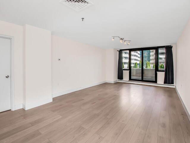 25 Rockledge Ave Unit 117, White Plains, NY 10601 - unfurnished room featuring light wood-style floors, visible vents, baseboards, and rail lighting