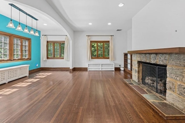 51 Valley Rd, Larchmont, NY 10538 - unfurnished living room with wood finished floors, recessed lighting, a stone fireplace, arched walkways, and radiator heating unit